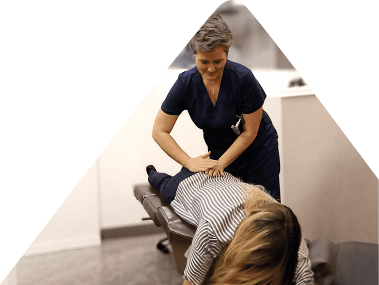 Dr Christy Flick working on a client's back, aligning their spine